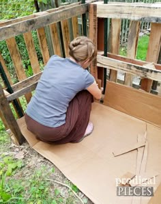 a woman kneeling down on the ground next to a wooden crate with wood sticks sticking out of it