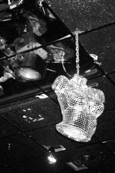 a black and white photo of an object hanging from the ceiling in a room filled with other items