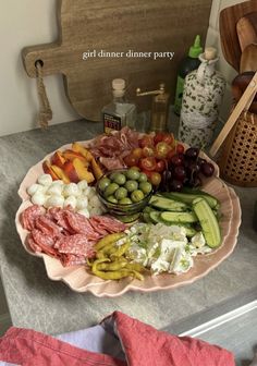 a platter filled with assorted meats and vegetables on top of a table