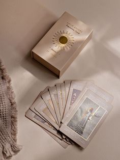 a deck of cards and a book on a table with a tasseled blanket