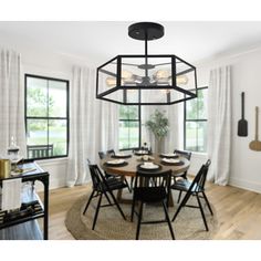 a dining room table with chairs and a chandelier hanging from the ceiling in front of windows