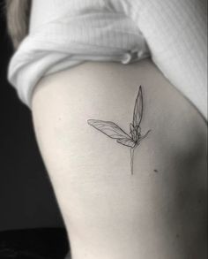 a woman's lower back tattoo with a dragonfly on her left side ribcage