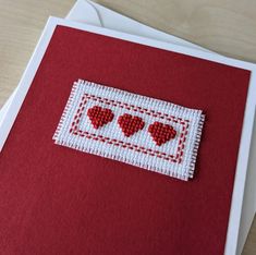 a red card with three hearts on the front and two smaller ones on the back