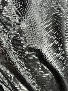 a black and white photo of a snake skin pattern on a jacket with zippers