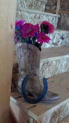 a cowboy boot with flowers in it sitting on some steps