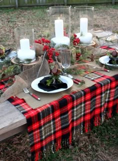 the table is set with plaid cloth and candles