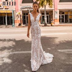 a woman in a wedding dress standing on the street