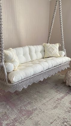 a white couch sitting on top of a wooden swing