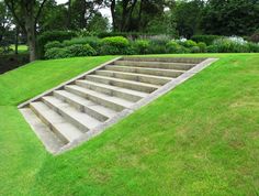 a concrete staircase in the middle of a grassy area