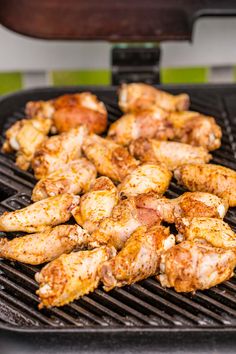 chicken is cooking on the grill with other food items