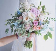 a bride holding a bouquet of flowers in her hands