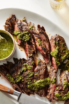 grilled steaks with pesto sauce on a white plate