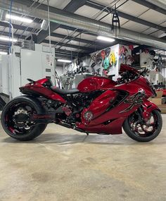 a red motorcycle is parked in a garage