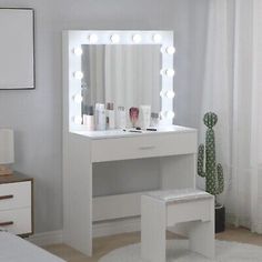 a white vanity with lights on it in a bedroom