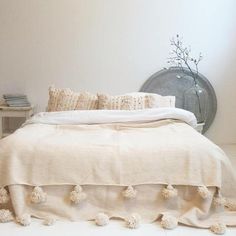 a white bed with pom poms on it