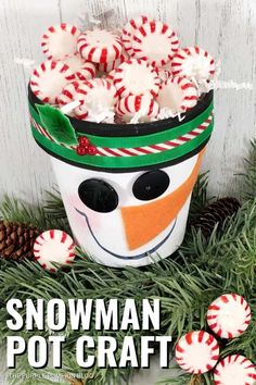 a snowman pot with candy canes in it