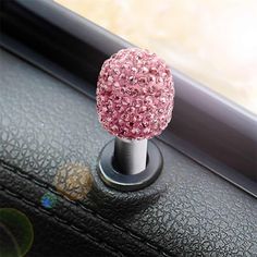 a car dashboard with a pink and silver ball on it's center console knob