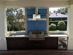 an outdoor kitchen under construction with blue paint on the wall and cabinets in front of it