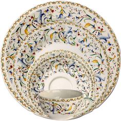 a set of four dinner plates with birds and flowers on the rim, all in different colors