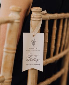 a close up of a wooden chair with a sign attached to the back of it