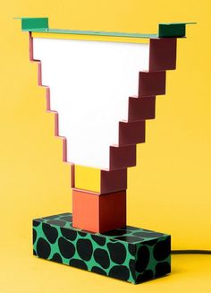 a lamp made out of colored blocks on a yellow background with a black and white dot pattern