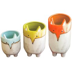 three ceramic cups with animals painted on the sides and one has an orange fox head