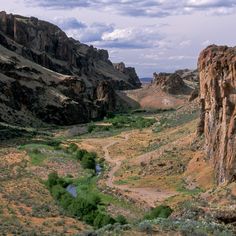 a river running through a valley surrounded by mountains