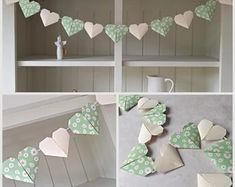 some paper hearts are hanging on the wall and in front of a shelf with other items