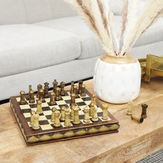 a marble chess board with feathers on it and other items sitting on the coffee table