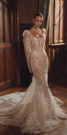 a woman in a wedding dress standing on a wooden floor with her back to the camera