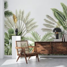 a living room with palm leaves on the wall and two chairs in front of it