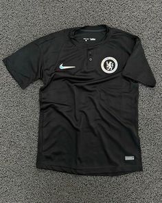 the nike soccer shirt is laying on the floor with it's logo on it