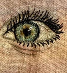 an embroidered eye is shown in this close up photo