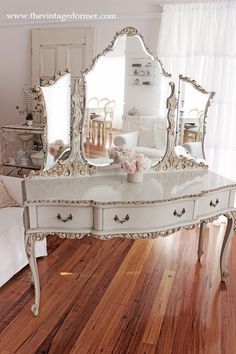 a white dresser with a mirror on top of it