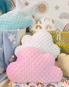 a pile of stuffed animals sitting next to each other on top of a bed covered in blankets and pillows