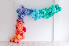 an art installation made out of yarn balls in a white room with polka dots on the floor