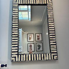 there is a mirror with pictures on the wall above it and a light in the corner