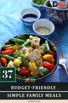 a bowl filled with vegetables and meat on top of a blue table