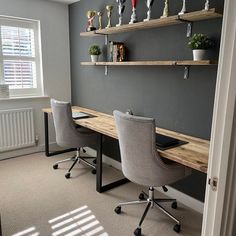 a desk with two chairs and shelves on the wall