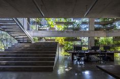 an office building with stairs leading up to the second floor and computer desks on either side