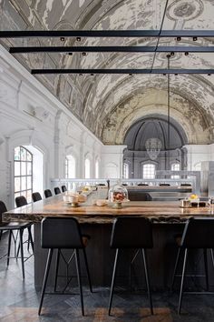 a large dining table in the middle of a room with many chairs and tables around it