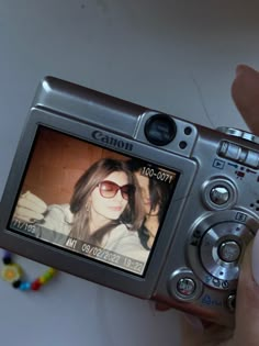 a person holding up a camera to take a picture with their reflection in the screen