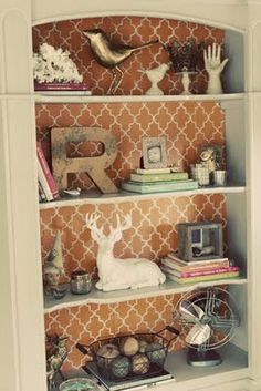 a book shelf filled with lots of books and knick knacks on top of it