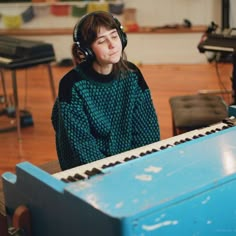 a woman wearing headphones sitting in front of an organ