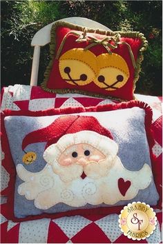 a santa clause pillow sitting on top of a red and white checkered blanket