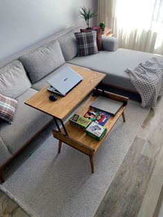 a living room with a gray couch and wooden coffee table