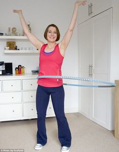 a woman is holding a hula hoop in the middle of her body and smiling