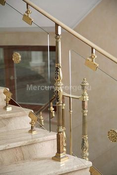 a set of stairs with gold railings and handrails in a home setting