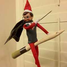 an elf with glasses and a black jacket is holding a paintbrush in his hand