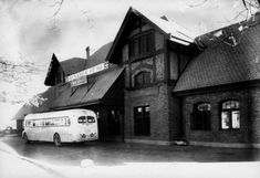 an old black and white photo of a bus parked in front of a building